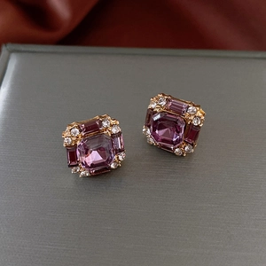 Macro shot of square purple crystal stud earrings with gold plating and rhinestones