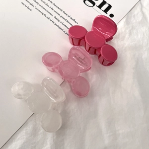 Detailed shot of pink, translucent, and white medium-sized claw clips on white fabric
