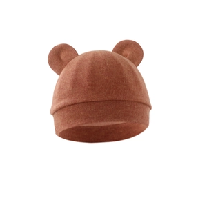 Close-up of rust red baby knit hat featuring cute 3D bear ears and soft wool texture
