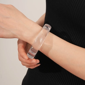 Detailansicht eines transparenten Harzarmreifs am Modell im minimalistischen Design