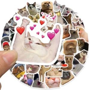 Close-up of a funny cartoon cat sticker being held by hand to show size and detail