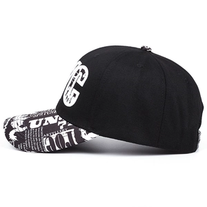 Hip hop snapback hat with white UN embroidery and black and white newspaper print brim