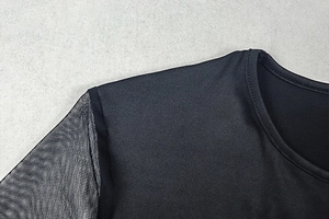 Close-up of black mesh sleeve stitching and crew neckline detail on fitted dress