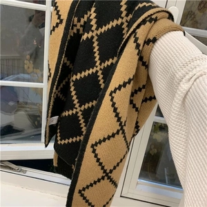 Detail showing soft knit texture and brown plaid pattern of a thick warm winter scarf