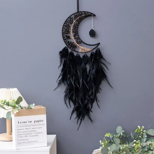 Macro detail of black moon dreamcatcher with tree of life design and feather accents