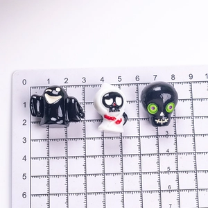 3D cartoon Halloween ghost and skull figurines on measuring grid for size reference