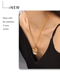 Detail of vintage bamboo style pendant necklace in gold plated titanium steel with zircons