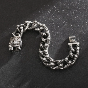 Detailed view of interconnected silver skull links on a punk style stainless steel bracelet