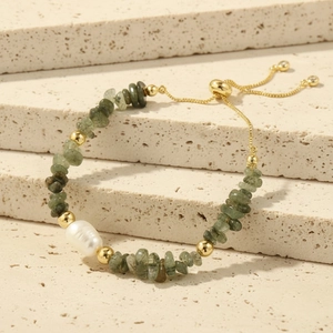 Detail of beaded bracelet featuring green crushed stone and white irregular freshwater pearl