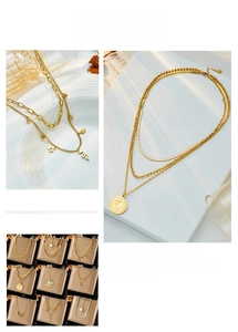 Detail showing layered gold-plated necklaces with pearl and eye-shaped pendants