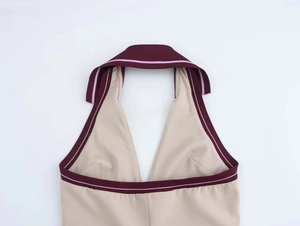 Close-up of ribbed knit halter neck dress in beige with contrast red and pink trim