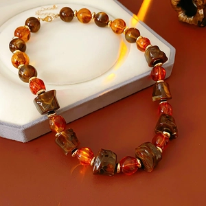 Detailed view of irregular brown and amber beads with gold spacers on this elegant necklace