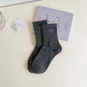Close-up of dark grey crew socks featuring white polka dots and sweet lettuce edge cuffs