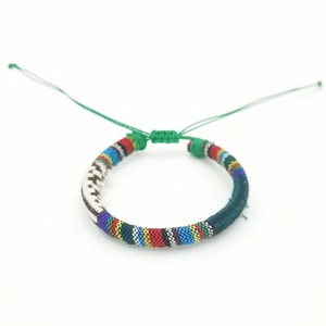 Detailed view of colorful Bohemian hand-woven surf bracelet with adjustable green cords
