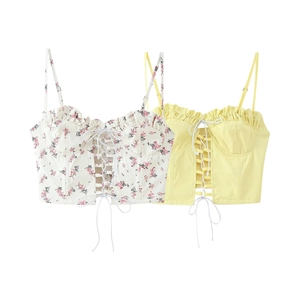 Flat lay of floral and yellow lace-up camisoles with adjustable straps and ruffles