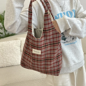 Close-up of vintage plaid tote bag with colorful wool pattern and fabric label detail