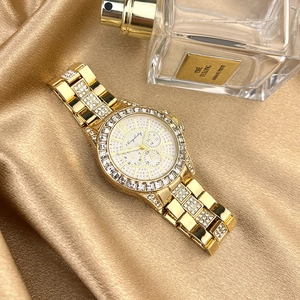 Detail of luxury gold rhinestone watch on satin fabric with cherrybaby logo on dial