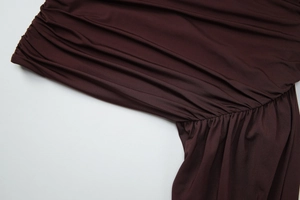 Détail des fronces sur la robe moulante marron foncé avec textures drapées élégantes