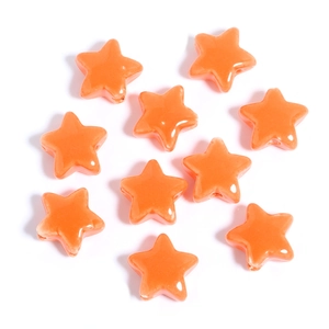Macro shot of bright orange star-shaped ceramic beads for DIY jewelry making