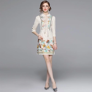 Elegant beige spring dress with heavy floral embroidery and delicate bow tie detail
