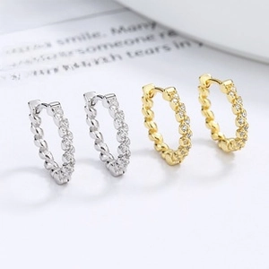 Detail of twisted silver and gold hoop earrings with sparkling micro-pave cubic zirconia