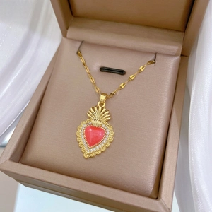 Detail of vintage gold heart pendant with red stone and pavé zircon in jewelry box