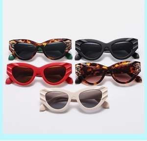Flat lay of retro cat eye sunglasses in leopard, black, red, and cream with textured frames
