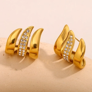 Detailed macro view of gold-plated stainless steel earrings with sparkling white crystals