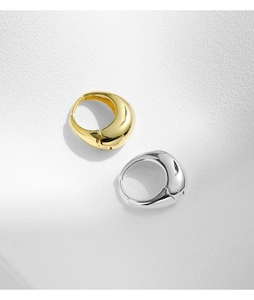 Close-up of teardrop hoop earrings in gold and silver finish with polished surface