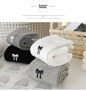 Detail of embroidered bow on knit socks in black, white, and grey Japanese style
