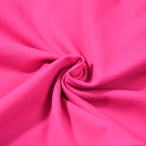 Détail du tissu en maille rouge rose doux montrant la texture fine et le drapé spirale