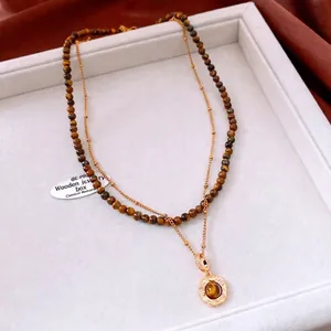 Double-layered 18K gold plated necklace with tiger eye beads and a round pendant