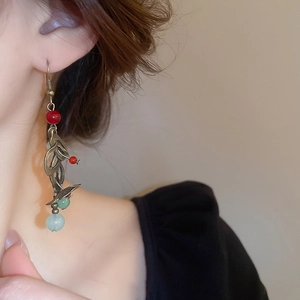 Détail d'une boucle d'oreille ethnique à pampilles avec feuilles en bronze et perles