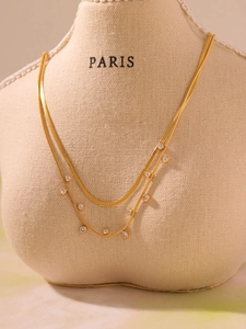 Détail du collier double rang plaqué or 18k avec chaîne serpent et pendentifs en zircon