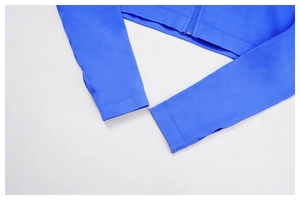 Detail of royal blue yoga jacket featuring seamless knit texture and functional thumbholes