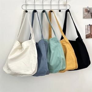 Serie di borse tote minimaliste in tela appese in cinque colori diversi su un supporto metallico