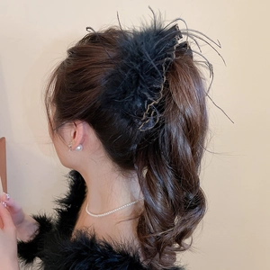 Detail of elegant black feather hair clip with gold-rimmed lace on a ponytail
