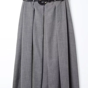 Detail of grey high-waisted pleated skirt with fine suit texture and a thin black belt