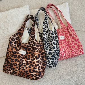 Detailed view of large leopard print canvas tote bags in brown, grey and pink colors