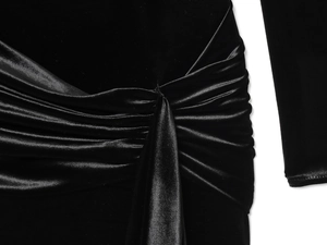 Detailed close-up of the pleated knot design on black velvet and satin dress fabric