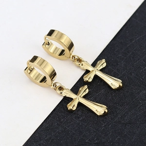 Close-up of highly polished golden cross pendant earrings on a black and white background