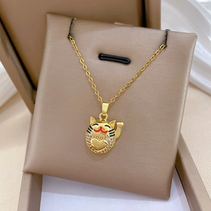 Macro view of gold Lucky Cat pendant with sparkling zircons and red heart detail