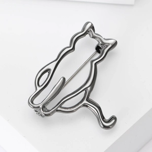 Detailed close-up of a gun-grey minimalist cat-shaped hollow metal brooch with a smooth finish