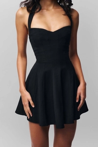 Dettaglio mini abito nero con scollo all'americana, cuciture a corsetto e vita sottile