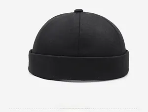 Side view detail of a black cotton docker hat with white embroidery and twill texture