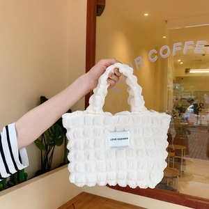 Detail showing white bubble texture tote bag with LOVE SOZAKKA label in a cafe setting