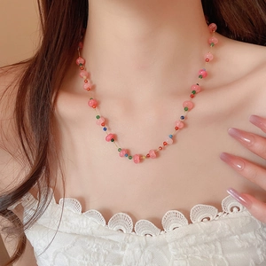 Detail of pink crystal beaded necklace with colorful accents on a female model