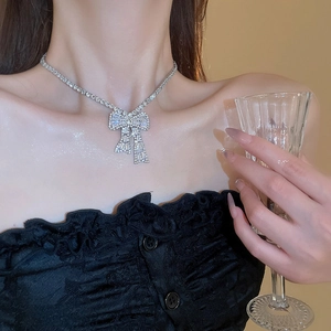 Macro shot of silver bow pendant earrings with glittering trapezoid zircon inlay details