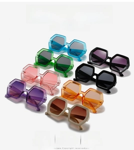 Collection of oversized hexagonal sunglasses in seven vibrant colors on white backdrop