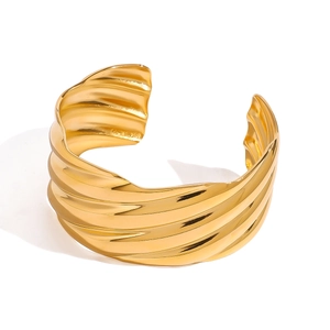 Minimalist 18k gold stainless steel open bangle with wave texture on white background